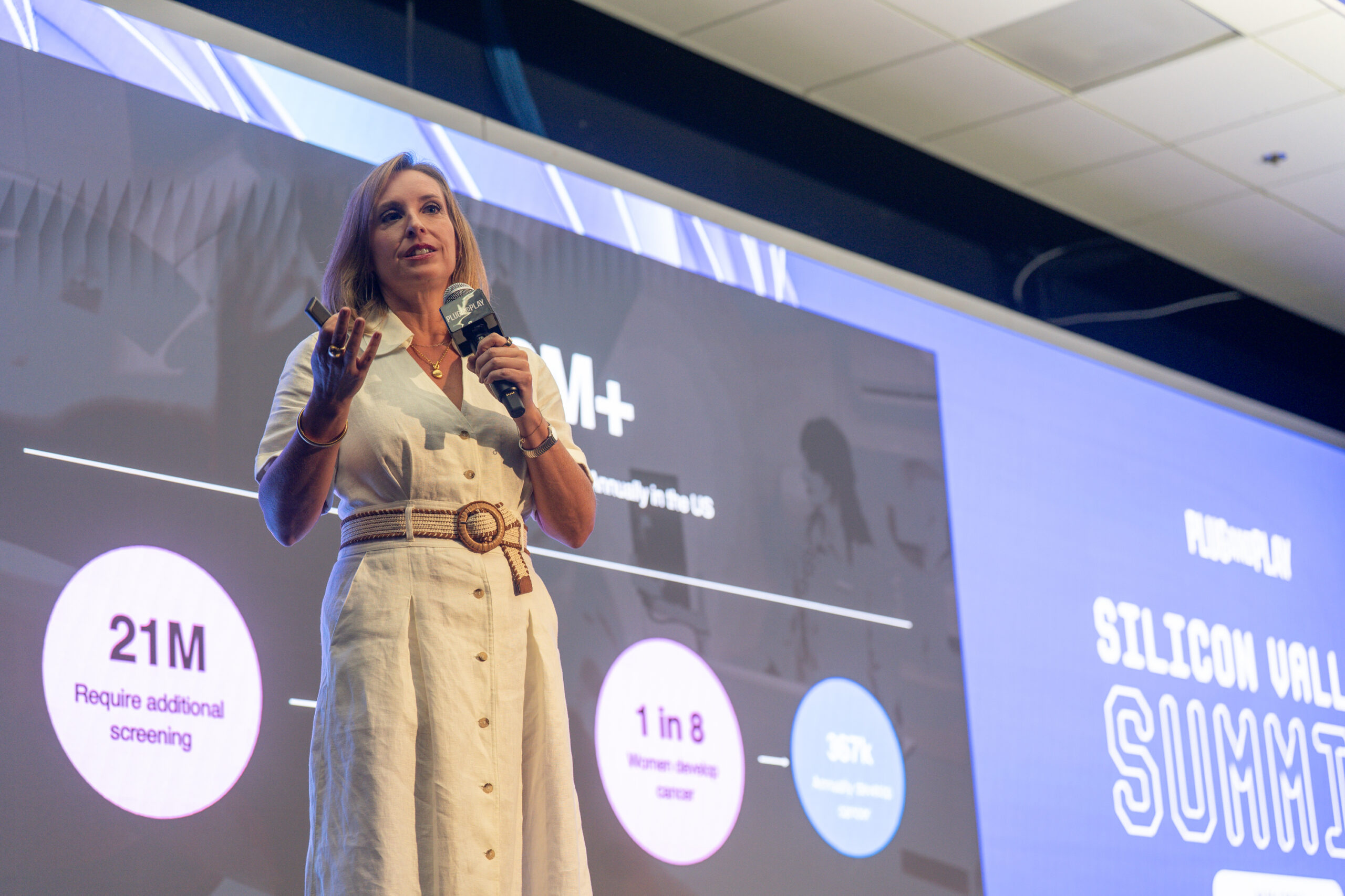Marissa Fayer presenting at a medical conference with imaging slides on screen behind her
